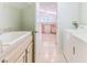 Bright laundry room boasts tile floors, washer, dryer, and utility sink, conveniently located near the kitchen at 1032 Walnut Hill Ct, Spring Hill, FL 34609