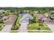 Aerial view of a single-story home with a two car garage, lush lawn, and tranquil lake in the backyard at 1053 Winding Willow Dr, Trinity, FL 34655
