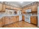 Bright kitchen with wood cabinets, countertops, white appliances, and wood flooring at 1053 Winding Willow Dr, Trinity, FL 34655
