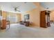 Cozy living room featuring neutral walls, neutral carpeting, a ceiling fan and a large entertainment center at 1053 Winding Willow Dr, Trinity, FL 34655