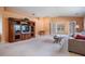 Open living room with views to the sunroom and the lake, neutral walls, and a large entertainment center at 1053 Winding Willow Dr, Trinity, FL 34655