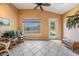 Cozy sun room with tile floors, vaulted ceilings, wicker furniture, and a scenic lake view at 1053 Winding Willow Dr, Trinity, FL 34655