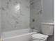 Bathroom featuring white marble wall tiles, gray walls, shower head, and toilet at 10906 Carnelian Ln, Riverview, FL 33578