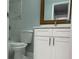 Bathroom with toilet, white sink cabinet with white countertop and light-stained wood frame mirror at 10906 Carnelian Ln, Riverview, FL 33578