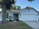 Charming single story home featuring a two-car garage and mature landscaping at 10906 Carnelian Ln, Riverview, FL 33578
