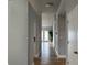Bright hallway featuring hardwood floors and a modern chandelier light fixture at 10906 Carnelian Ln, Riverview, FL 33578