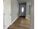 Inviting hallway with wood-look floors and neutral paint, leading to the front door at 10906 Carnelian Ln, Riverview, FL 33578