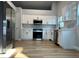 Modern kitchen featuring stainless steel appliances, white cabinets and hardwood floors at 10906 Carnelian Ln, Riverview, FL 33578