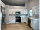 Modern kitchen featuring stainless steel appliances, white cabinets and hardwood floors at 10906 Carnelian Ln, Riverview, FL 33578