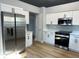 Modern kitchen featuring stainless steel appliances, white cabinets, and a light grey wall at 10906 Carnelian Ln, Riverview, FL 33578