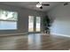 Well lit living room featuring hardwood floors, ceiling fan and access to the yard at 10906 Carnelian Ln, Riverview, FL 33578