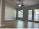 Light-filled living room features wood-look floors and access to the backyard with a ceiling fan to keep you cool at 10906 Carnelian Ln, Riverview, FL 33578