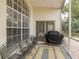 Screened-in patio features a grill, outdoor seating, and views of the surrounding landscape at 10906 New Brighton Ct, New Port Richey, FL 34654