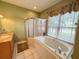 Bathroom featuring a soaking tub, separate shower, and window with privacy blinds at 1121 Riveredge Dr, Tarpon Springs, FL 34689