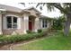 Charming home featuring well-maintained landscaping, decorative shutters, and a red front door at 1121 Riveredge Dr, Tarpon Springs, FL 34689