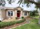 Inviting home with a red double-door entry, manicured landscaping, and a decorative water fountain at 1121 Riveredge Dr, Tarpon Springs, FL 34689