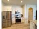 Modern kitchen features stainless steel appliances, granite countertops, and white cabinets at 1121 Riveredge Dr, Tarpon Springs, FL 34689