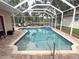 Covered pool area with view of a lake, lounge chairs, and a manicured lawn at 1121 Riveredge Dr, Tarpon Springs, FL 34689