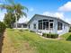 A beautiful lawn, screen enclosed patio, and well-manicured landscaping in the backyard of this lovely home at 11342 Hollander Ave, Hudson, FL 34667