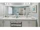 Bathroom featuring double sinks, large vanity mirror, modern cabinets, and tiled walls with coastal accents at 11342 Hollander Ave, Hudson, FL 34667