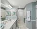 Clean bathroom with walk-in shower, tiled floor, and vanity with framed mirror and decor at 11342 Hollander Ave, Hudson, FL 34667