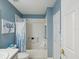 Clean bathroom features tub with shower, blue accents and white fixtures at 11342 Hollander Ave, Hudson, FL 34667