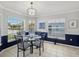 The dining area features a modern light fixture, wainscotting, and bright natural light from multiple windows at 11342 Hollander Ave, Hudson, FL 34667