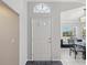 A brightly lit foyer, with a glass-accented front door, tile floors, and dining room view at 11342 Hollander Ave, Hudson, FL 34667