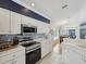 Bright kitchen features white cabinets, stainless steel appliances, and tiled backsplash with adjacent dining area at 11342 Hollander Ave, Hudson, FL 34667