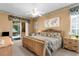 Bright main bedroom with ceiling fan, king bed, and sliding door to the pool at 11443 Marsh Creek Ct, New Port Richey, FL 34654