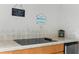 Outdoor kitchen features a flat top grill, storage, and humorous signs near a swimming pool at 11443 Marsh Creek Ct, New Port Richey, FL 34654