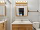 Bright bathroom featuring a wooden vanity and mirror with integrated lighting above at 11512 Yellow Birch Ct, New Port Richey, FL 34654