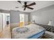 Comfortable bedroom featuring a bed, ceiling fan, and a view into the bathroom at 11512 Yellow Birch Ct, New Port Richey, FL 34654