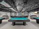 Large billiards room features multiple pool tables with overhead lighting at 11512 Yellow Birch Ct, New Port Richey, FL 34654