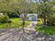 Inviting single-story home with lush landscaping, mature trees, and a long driveway at 11512 Yellow Birch Ct, New Port Richey, FL 34654