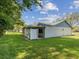 Rear exterior showcasing a fenced-in patio, manicured lawn, and the home's architectural details at 11512 Yellow Birch Ct, New Port Richey, FL 34654