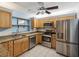 Well-lit kitchen with stainless steel appliances, tile flooring, and granite countertops at 11512 Yellow Birch Ct, New Port Richey, FL 34654