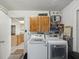 Laundry room featuring washer, dryer, and storage cabinets, with a glimpse into the kitchen at 11512 Yellow Birch Ct, New Port Richey, FL 34654