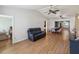 Open living space with wood floors, a comfortable black leather sofa, and a dining area in the background at 11512 Yellow Birch Ct, New Port Richey, FL 34654