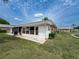 Exterior shot of the home's rear, featuring an enclosed patio and well-maintained yard at 11601 Bayonet Ln # 163A2, New Port Richey, FL 34654
