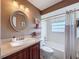 Bathroom featuring a round mirror, wood vanity, and a white tub and shower combination at 11601 Bayonet Ln # 163A2, New Port Richey, FL 34654
