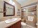 Bathroom with dark wood vanity, large mirror, and enclosed tiled shower with glass doors and a bench at 11601 Bayonet Ln # 163A2, New Port Richey, FL 34654