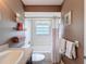Bathroom featuring a round mirror, wood vanity, and a white tub and shower combination at 11601 Bayonet Ln # 163A2, New Port Richey, FL 34654