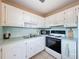 Efficient kitchen featuring white cabinetry and appliances for a functional cooking space at 11601 Bayonet Ln # 163A2, New Port Richey, FL 34654
