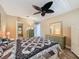 Spacious bedroom features ceiling fan, en suite bathroom and a large bed with decorative quilt at 11601 Bayonet Ln # 163A2, New Port Richey, FL 34654