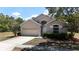 Inviting single-story home boasts a manicured lawn, an attached two-car garage, and decorative front windows at 12248 Colony Lakes Blvd, New Port Richey, FL 34654