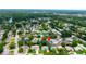 Aerial view of a residential area with lush tree coverage, a pond, and well-maintained homes at 12407 Gunstock Ln, Hudson, FL 34667