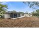 Back exterior view showcasing the screened porch and spacious backyard at 12407 Gunstock Ln, Hudson, FL 34667