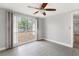 Bedroom with tile flooring, ceiling fan, and natural light from a large window at 12407 Gunstock Ln, Hudson, FL 34667