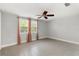 Bedroom with tile flooring, ceiling fan, and natural light from a large window at 12407 Gunstock Ln, Hudson, FL 34667